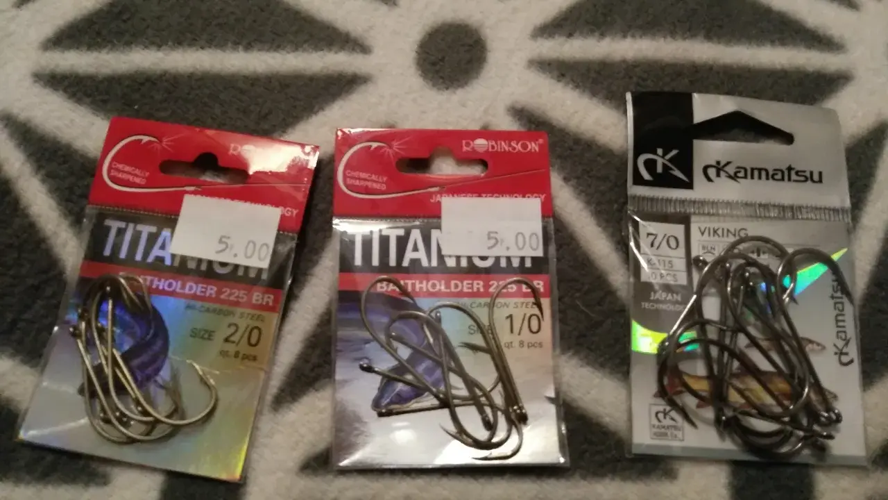 Trzy opakowania haczyków wędkarskich. Dwa z napisem "Titan", jeden z logo "Kamatsu". Idealny jaki haczyk na grunt dla każdego wędkarza.
