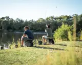 Dwóch mężczyzn łowi ryby nad jeziorem. Idealny dzień na wędkowanie, jak z kalendarza bran otobranie.