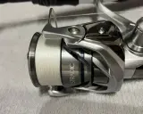 Kołowrotek Stradic z nawiniętą białą plecionką, idealny na spinning.