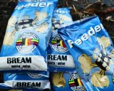 Kilka opakowań zanęt na leszcza "Feeder" z wizerunkiem belgijskiej flagi i napisem "3 x World Champion".