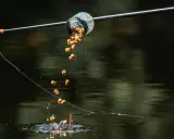 Zanęta do method feeder spada do wody, tworząc idealną chmurę przyciągającą ryby.