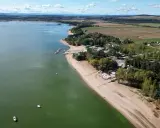 Piękny widok na Mietków Zalew z piaszczystą plażą, mariną i zielonymi terenami. Idealne miejsce na wypoczynek.