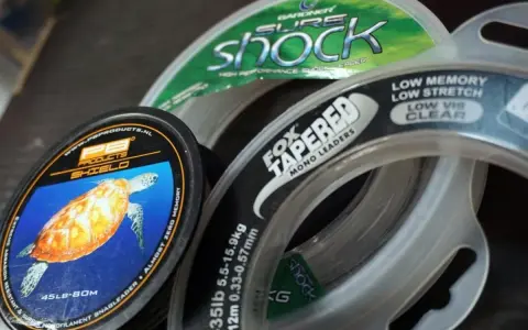 Wybór między żyłką a plecionką to kluczowa decyzja wędkarza. Na zdjęciu widać różne rodzaje żyłek, w tym PB Products Shield i Fox Tapered Mono Leaders.