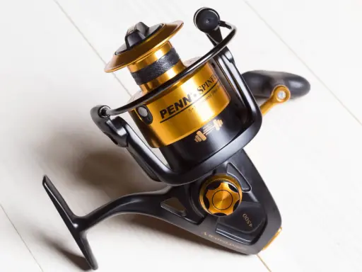 Czarny kołowrotek spinningowy Penn Spinfisher V 4500 ze złotymi akcentami, idealny do plecionki.