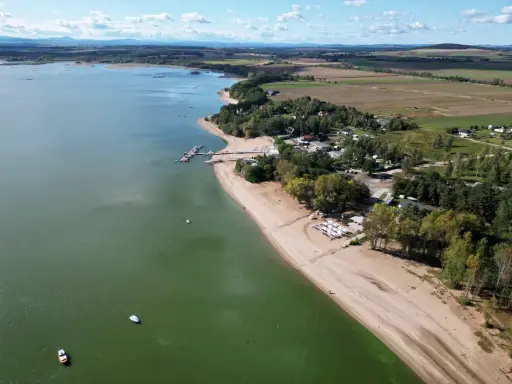 Piękny widok na Mietków Zalew z piaszczystą plażą, mariną i zielonymi terenami. Idealne miejsce na wypoczynek.