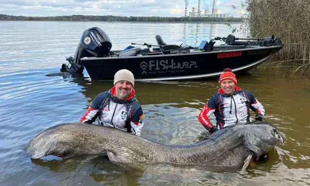 Dwóch wędkarzy z gigantycznym sumem w wodzie. Pytanie brzmi: jaki haczyk na suma pozwolił wyciągnąć taką rybę?