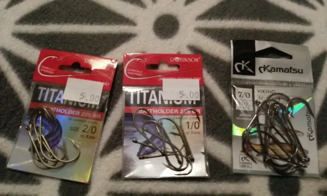 Trzy opakowania haczyków wędkarskich. Dwa z napisem "Titan", jeden z logo "Kamatsu". Idealny jaki haczyk na grunt dla każdego wędkarza.