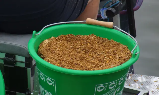 Zielone wiadro z zanętą wędkarską 25kg, gotowe do akcji.
